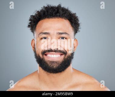 Befreie dein Lächeln. Studio-Porträt eines attraktiven jungen Mannes, der vor grauem Hintergrund posiert. Stockfoto