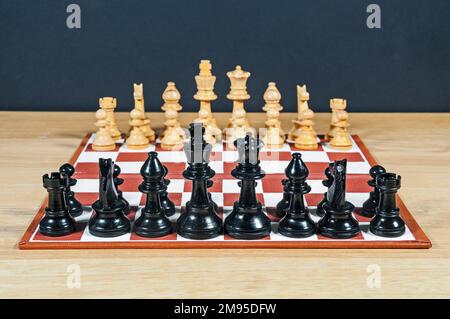 Kleines Schachset und Schachbrett mit nahezu scharfen Steinen. Stockfoto