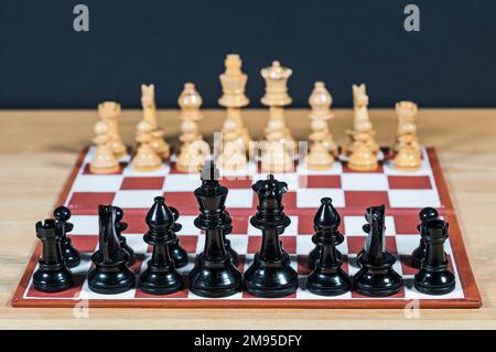 Kleines Schachset und Schachbrett mit weit entfernten unscharfen Teilen. Stockfoto