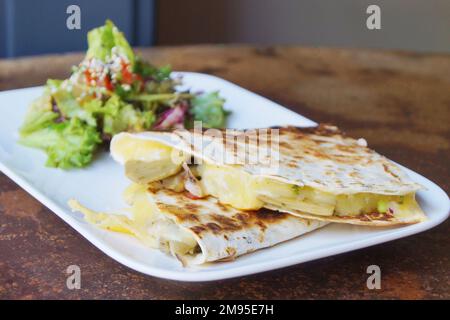 Die Quesadilla ist ein mexikanisches Gericht, das aus einer Mais- oder Weizentortilla besteht, die in der Mitte gefaltet ist und je nach Region mit Käse gefüllt werden kann Stockfoto