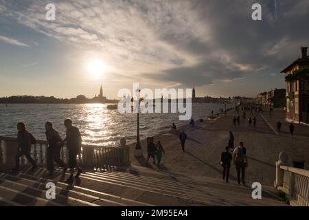 Blick auf Venedig bei Sonnenuntergang von der Riva degli Schiavoni, mit dem San Mark Turm in der Ferne Stockfoto