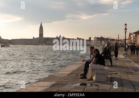 Blick auf Venedig bei Sonnenuntergang von der Riva degli Schiavoni, mit dem San Mark Turm in der Ferne Stockfoto