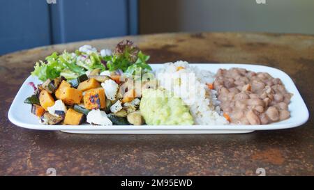 Mexikanische Kombi-Platte mit gegrilltem Gemüse, Guacamole, Bohnen und Reis. Stockfoto