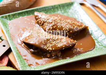 Mexikanische Tacos mit Mole-Sauce. Der Begriff Mole bezieht sich auf verschiedene Sorten hochgewürzter mexikanischer Saucen, die hauptsächlich aus Chili und Chili hergestellt werden Stockfoto