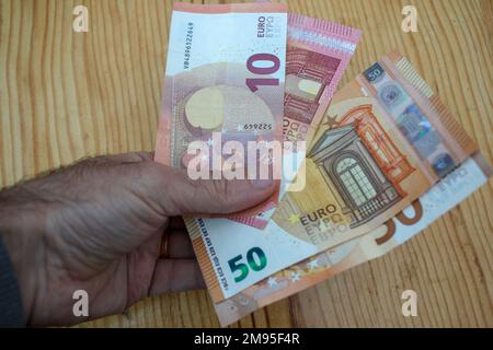 Zehn und fünfzig Euro Scheine in meiner linken Hand Stockfoto