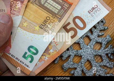 euro-Scheine und Weihnachtsschmuck auf dem Tisch der Wirtschaftskrise Stockfoto