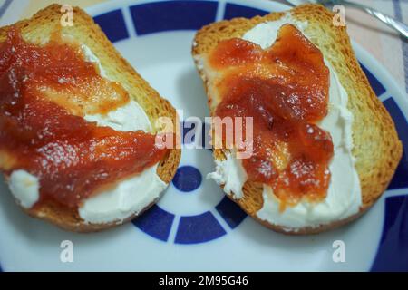 Zwei Scheiben getoastetes Brot mit Käse und Quitten Stockfoto