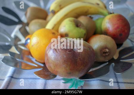 Fauler Apfel unter anderen Früchten in der Obstschale Stockfoto