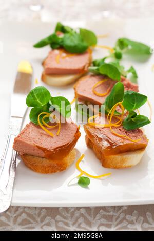Köstliche Ostervorspeise zum Weihnachtsessen. Hähnchenleberpastete mit Gelee und frischem Maissalat auf weißem Gericht. Stockfoto
