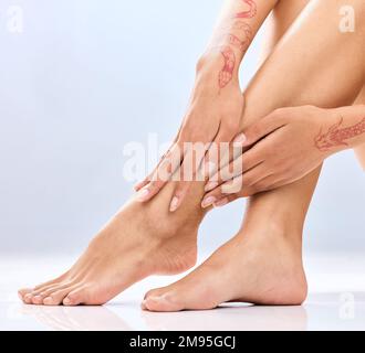 Das weichste Finish. Eine nicht wiedererkennbare Frau Beine im Studio vor blauem Hintergrund. Stockfoto