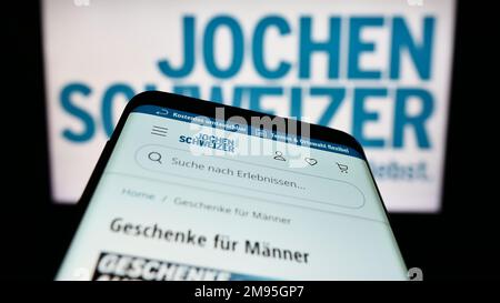 Mobiltelefon mit Website der deutschen Firma Jochen Schweizer GmbH auf dem Bildschirm vor dem Firmenlogo. Fokus auf oberer linker Seite des Telefondisplays. Stockfoto