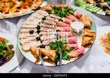 Aufschnitt von Fleisch auf dem Teller mit Sauce und Oliven im Restaurant Stockfoto