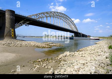 Niederlande, Ooyse Schependom, 23. August 2022: Flusstransport auf der Waal, Rheindelta, während der Dürre des Sommers 2022. Chemikalientanker an Stockfoto