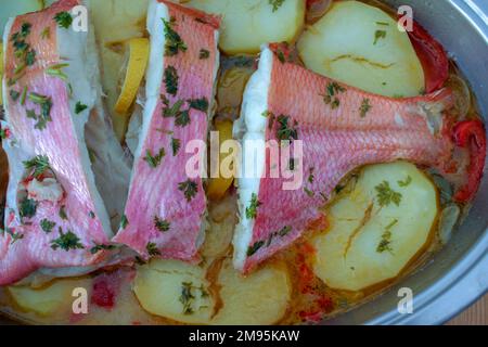 Leckere rote Brasse mit Kartoffeln, die zu Hause zubereitet werden Stockfoto