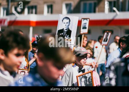 VICHUGA, RUSSLAND - 9. MAI 2015: Unsterbliches Regiment - Menschen mit Porträts ihrer Verwandten, Teilnehmer des Zweiten Weltkriegs, am Siegesfeiertag Stockfoto