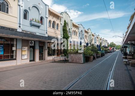 Christchurch, Neuseeland - 14. Dezember 2022: Straßenbahnlinien durch die farbenfrohen Gebäude der historischen New Regent Street im Zentrum von Chris Stockfoto