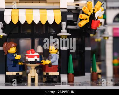 Tambov, Russische Föderation - 07. Januar 2023 Ein Lego-Geschäftsmann und eine Geschäftsfrau Minifigures sitzen hinter einem Tisch in einem Straßencafé und essen ein Ca Stockfoto