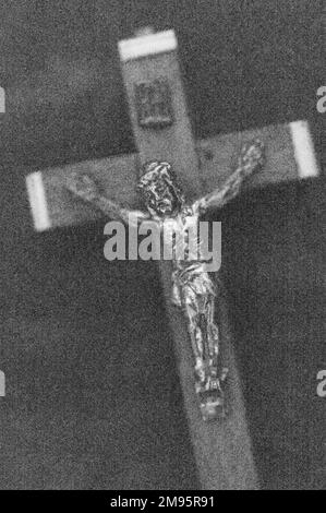 Monochromes Bild eines kleinen Holz- und Metallkruzifix-tragenden Jesus Christus Stockfoto