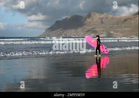 Surfer am Strand von Caleta de Famara, Playa de Famara, Lanzarote. Stockfoto