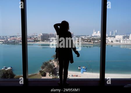 Eine Frau, die vor einem Panoramafenster steht und die Scheich-Zayid-Moschee sieht. Abu Dhabi. Abu Dhabi. Vereinigte Arabische Emirate. Stockfoto