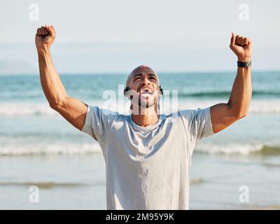 Der erfolgreiche Krieger arbeitet hart. Ein junger Mann feiert am Strand. Stockfoto