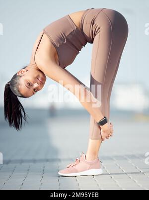 Verbesserung ihrer Gesundheit und Flexibilität. Porträt einer sportlichen jungen Frau, die sich beim Sport im Freien dehnt. Stockfoto