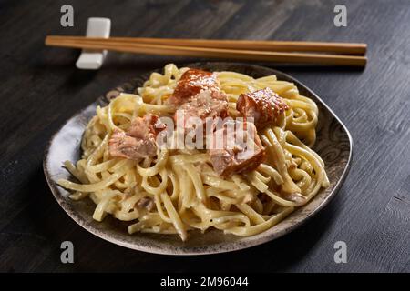 Lachssalat mit Nudeln, Sahne und Kräutern, mit Stäbchen zur Seite Stockfoto