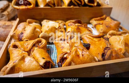 Spanische Snacks und Street Food, gebackener Kuchen Empanadilla mit verschiedenen Füllungen auf dem Markt in San-Sebastian, Spanien, aus nächster Nähe Stockfoto