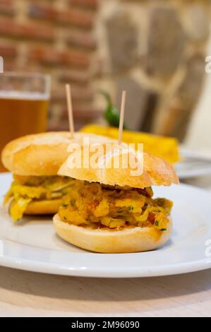Typischer Mini-Burger-Snack aus dem Baskenland, Pinchos oder Pinxtos, kleines Stück Brot mit verschiedenen Belägen, serviert in der Bar in San-Sebastian oder Bilba Stockfoto