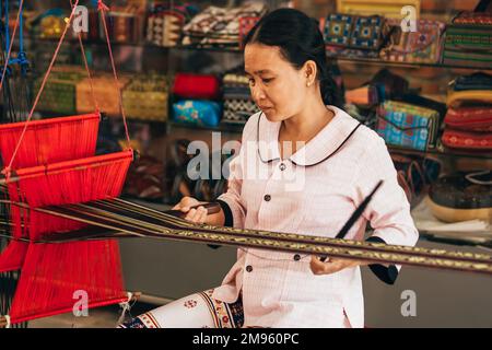 MUI NE, VIETNAM - 6. MÄRZ 2017: Asiatische Weberin arbeitet an einem traditionellen Webstuhl für Garnseidenwerkstatt Stockfoto