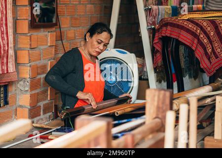 MUI NE, VIETNAM - 6. MÄRZ 2017: Weberinnen arbeiten in einer Werkstatt an einer traditionellen Webmaschine für Seide Stockfoto