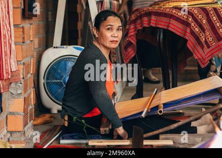 MUI NE, VIETNAM - 6. MÄRZ 2017: Weberinnen arbeiten in einer Werkstatt an einer traditionellen Webmaschine für Seide Stockfoto