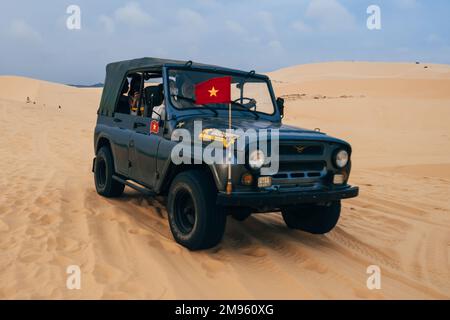 MUI NE, VIETNAM - 6. MÄRZ 2017: Touristen fahren im Sommer in einem Jeep in den White Sand Dunes Muine in Vietnam Stockfoto