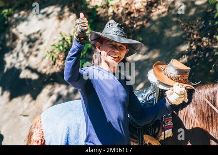 DA LAT, VIETNAM - 9. MÄRZ 2017: Porträt eines freundlichen vietnamesischen Mannes im Alter des Lächelns. Glücklicher Asiate mit Hut und Pferd im Cowboy-Image Stockfoto