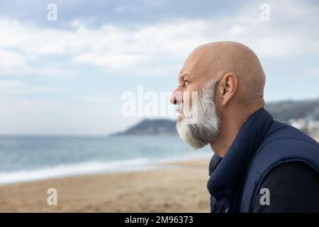 Nahaufnahme eines gutaussehenden Erwachsenen mit grauen Haaren und Blick auf das Meer Stockfoto