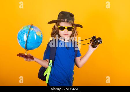 Reise- und Abenteuerkonzept. Kleiner Junge, Touristenforscher mit Welt des Globus. Entdeckung, Erkundung und Bildung. Studio-Einzelporträt. Stockfoto
