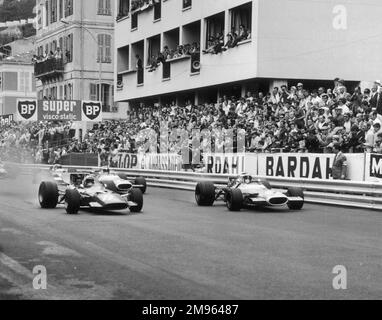 Jackie Stewart, in einem Matra-Ford (7), führt Chris Amons Ferrari (11) zu Beginn des Monaco Grand Prix vom Raster weg. Beide konnten das Rennen nicht beenden. Stockfoto