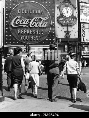 Fußgänger überqueren die Straße vor einem riesigen Coca-Cola-Werbespot im Piccadilly Circus. Stockfoto