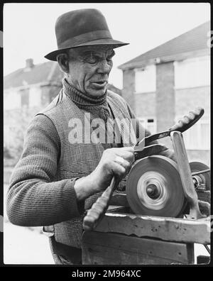 Henry Jones, mobiler Schleifer, schärft ein Messer an seinem Schleifstein, Horley, Surrey, England. Stockfoto