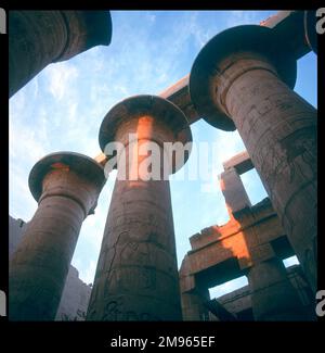 Die „Papyrus“-Säulen der Großen HYPOÄHNLICHEN HALLE bei Sonnenuntergang. Begonnen in der Herrschaft von Ramses I und vollendet in der Herrschaft von Ramses II, Karnak Theben (modernes Luxor), Ägypten Stockfoto