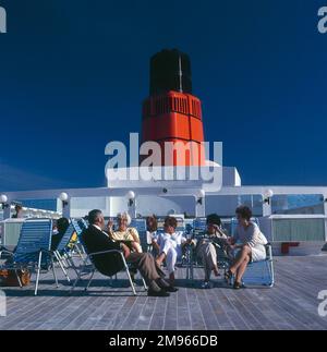 Passagiere entspannen sich auf dem Sonnendeck des Schiffes Queen Elizabeth II (QE2) Stockfoto