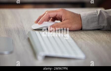 Alle Informationen sind für mich zugänglich. Ein unbekannter Geschäftsmann, der im Büro Tastatur und Maus benutzt. Stockfoto