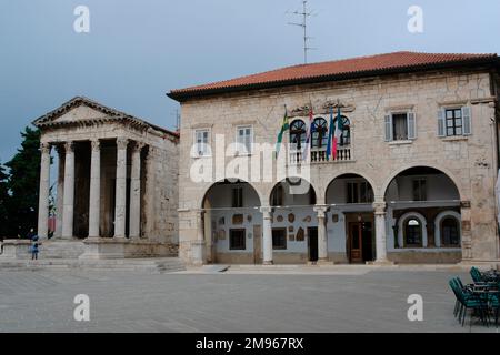 Der Tempel von Rom und Augustus (links) und das Rathaus (rechts) in Pula an der westlichen Adriaküste, Istrien, Kroatien. Stockfoto