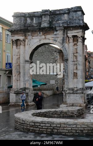 Der Triumphbogen der Sergii in Pula an der Westküste Istriens, Kroatien. Dieser antike römische Bogen erinnert an drei Brüder der Familie Sergii, insbesondere Lucius Sergius Lepidus, ein Tribun, der in der Schlacht von Actium kämpfte. Er wurde von der Frau von Lepidus, Salvia Postuma Sergia, bezahlt und wurde ursprünglich als Stadttor benutzt. Stockfoto