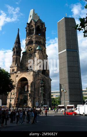 Die evangelische Kaiser-Wilhelm-Gedächtniskirche am Kurfürstendamm in Berlin. Es wurde 1943 bei einem Bombenangriff schwer beschädigt. Das gegenwärtige Gebäude, bestehend aus einer Kirche mit einem angehängten Foyer und einem separaten Glockenturm mit einer angehängten Kapelle, wurde zwischen 1959 und 1963 erbaut. Der beschädigte Turm der alten Kirche wurde erhalten und das Erdgeschoss wurde in eine Gedenkhalle umgewandelt. Stockfoto