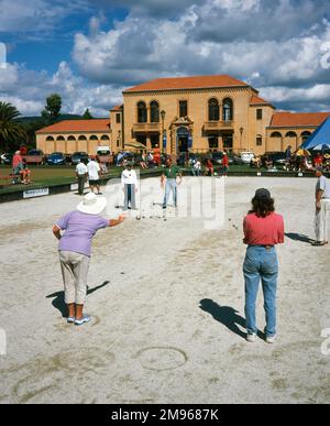 Leute spielen Boule in Government Gardens, Rotorua, North Island, Neuseeland. Das Gebäude im Hintergrund ist das Blue Baths, ein historisches Zentrum, das 1933 erbaut wurde und ein Wellnesscenter, Swimmingpools und Räume für gesellschaftliche und geschäftliche Veranstaltungen kombiniert. Stockfoto