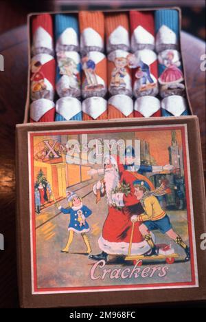 Eine schöne Schachtel mit weihnachtlichen Crackern aus den 1920er Jahren, mit intaktem Inhalt und dem Deckel mit einem hellen und fröhlichen Bild von Weihnachtsmann, der von einem Polizisten und zwei Kindern über die Straße geholfen wurde. Stockfoto