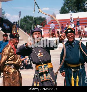 Männliche Bogenschützen nehmen während des jährlichen Naadam Festivals im Stadion Ulaanbaatar (oder Ulan Bator), der Hauptstadt der Mongolei, an einem Wettbewerb Teil. Typische Spiele, die während dieses Wettbewerbsfestivals gespielt werden, sind Ringen, Bogenschießen und Pferderennen. Stockfoto