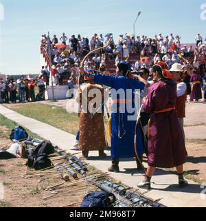 Bogenschützen nehmen während des jährlichen Naadam Festivals im Stadion Ulaanbaatar (oder Ulan Bator), der Hauptstadt der Mongolei, an einem Wettbewerb Teil. Typische Spiele, die während dieses Wettbewerbsfestivals gespielt werden, sind Ringen, Bogenschießen und Pferderennen. Stockfoto