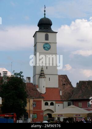 Blick auf den weißen Uhrenturm auf dem kleinen Platz (Piata Mica) in Sibiu, Siebenbürgen, Rumänien. Der Turm ist bekannt als Turnul Sfatului (Turm des Rates) und wurde im 13. Jahrhundert erbaut. Stockfoto